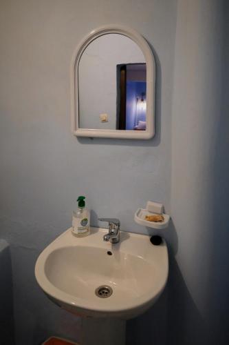 a bathroom with a white sink and a mirror at Riad Nerja in Chefchaouene