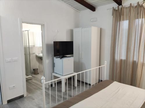 sypialnia z łóżkiem, telewizorem i komodą w obiekcie Affittacamere Ca der Culunellu w mieście Soviore