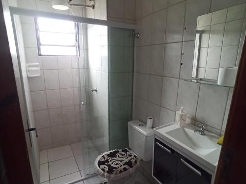 a bathroom with a shower and a toilet and a sink at Apto com estacionamento, piscina e churrasqueira in Bragança Paulista