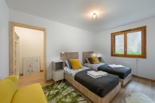 1 dormitorio con 2 camas y silla amarilla en Perle De Savoie - Apt B303 - BO Immobilier - remises sur les forfaits de skis Châtel ou Portes du soleil, en Châtel