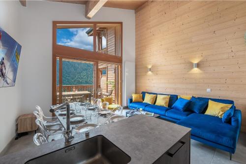 un salon avec un canapé bleu et une table dans l'établissement Perle De Savoie - Apt B303 - BO Immobilier - Châtel - Multipass 2025 Été offert par votre hôte, à Châtel