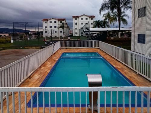 a swimming pool on the deck of a house at Apto com estacionamento, piscina e churrasqueira in Bragança Paulista