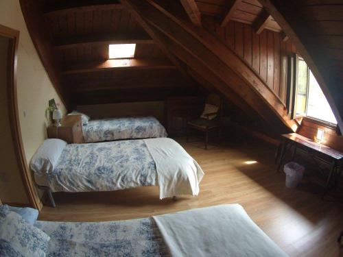1 dormitorio con 2 camas en un ático en Albergue Camino y Leyenda, en Trabadelo