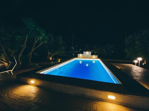 a swimming pool at night with lights on it at La Maison One B&B in Carovigno