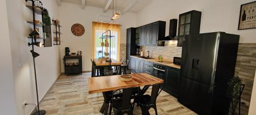 a kitchen with a wooden table and a refrigerator at Janus Casa nel Verde - Relax Pool & Spa in Giano Vetusto