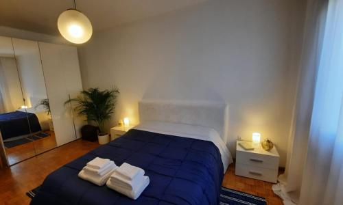 a bedroom with a blue bed with towels on it at Verdisuite - Trento centro - Parcheggio privato gratuito in Trento