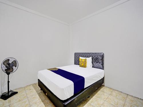 um quarto com uma cama e uma ventoinha em SPOT ON 92452 Griya Sandi Homestay Syariah em Banyuwangi