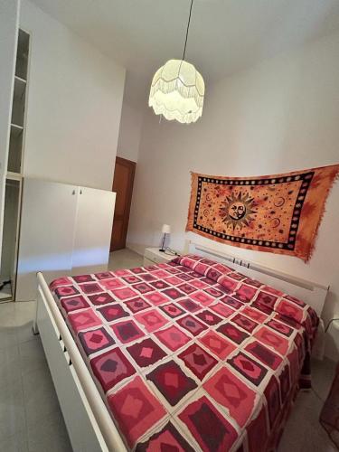 una camera da letto con un grande letto con un piumone rosso di Casa Vacanze Sant'Orsola a Trinità dʼAgultu