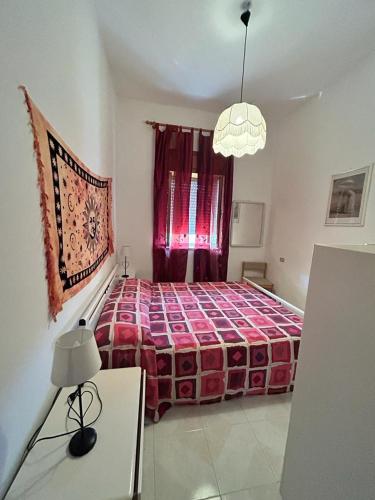 una camera da letto con un grande letto con una coperta rossa di Casa Vacanze Sant'Orsola a Trinità dʼAgultu