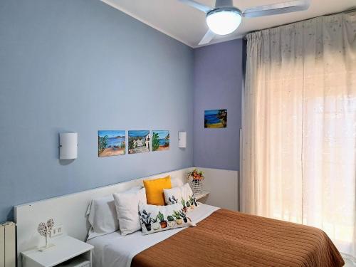 a bedroom with a bed with blue walls and a window at Castel Sant'Angelo sea view in Licata