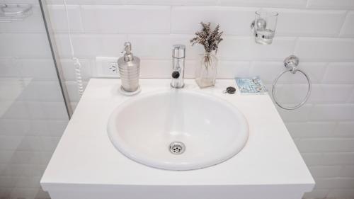 a white sink in a white bathroom with flowers on it at Modo Villa - Cabaña in Villa La Angostura