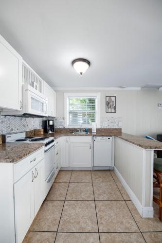 a kitchen with white cabinets and a tile floor at Pirates Pointe Resort in Ruskin
