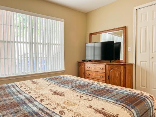 a bedroom with a bed and a tv and a mirror at Lake Front 2BR Walk-In with Large Deck - FREE TICKETS INCLUDED - 79-1 in Branson