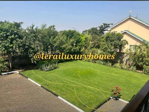 a backyard with a lawn with a hose at Lerai Homes in Arusha