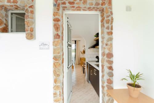 a kitchen with white walls and a brick wall at Althea Apartments in Kolimbia