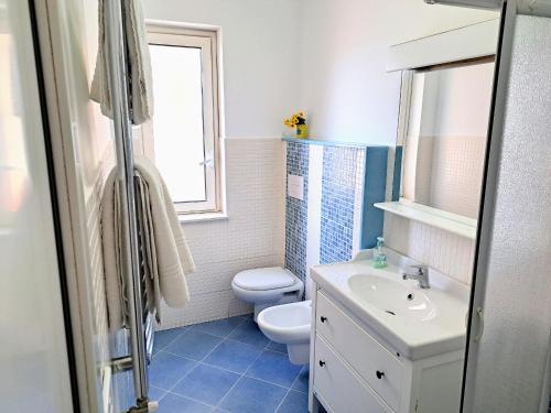 a bathroom with a toilet and a sink and a window at Castel Sant'Angelo sea view in Licata