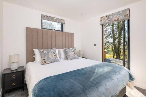 a bedroom with a large bed and two windows at Oak Tree, Penruddock in Penruddock