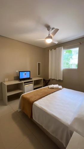 a bedroom with a large bed and a television at Hotel Rio in Guarujá
