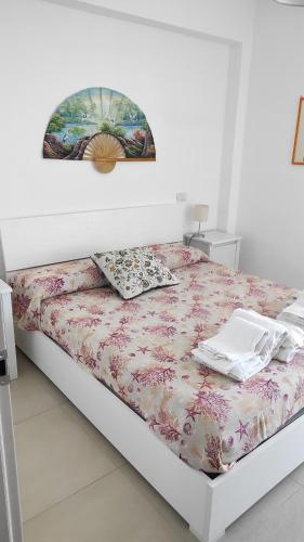 een witte slaapkamer met een bed met een laptop erop bij Appartamento Betty in Porto Santo Stefano