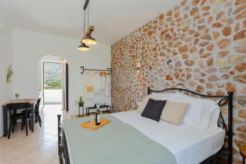 a bedroom with a bed and a stone wall at Althea Apartments in Kolimbia