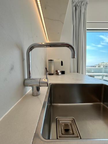 um lavatório de cozinha com uma torneira ao lado de uma janela em Penthouse William em Koksijde