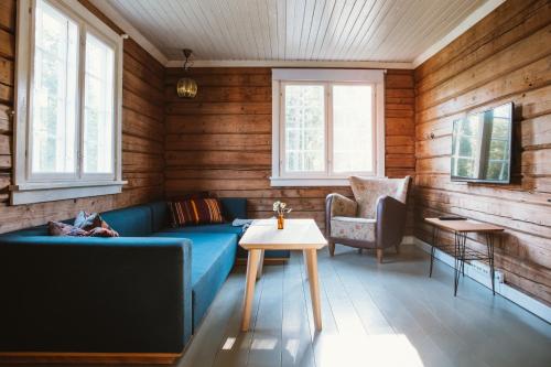 a living room with a blue couch and a table at Breiva Gjestegaard og Glamping in Bø