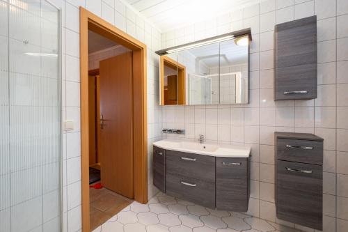 La salle de bains est pourvue d'un lavabo et d'un miroir. dans l'établissement Haus 1, à Ückeritz