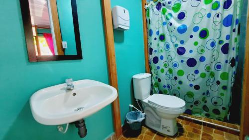 a bathroom with a sink and a toilet and a mirror at Villa Marlen Palomino in Palomino