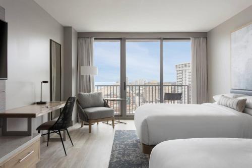 a hotel room with two beds and a desk and a view at Marriott Virginia Beach Oceanfront Resort in Virginia Beach