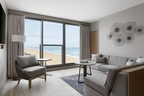 a living room with a couch and chairs and the ocean at Marriott Virginia Beach Oceanfront Resort in Virginia Beach