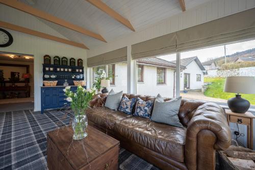 a living room with a brown leather couch at Balmridge House, Loch Ness, Bed & Breakfast in Drumnadrochit