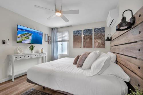 a white bedroom with a large bed and a ceiling fan at Tower 9 #2 in Oceanside