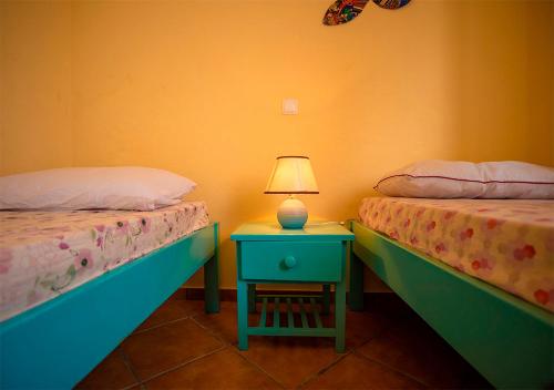 a bedroom with two beds and a table with a lamp at Villa Atum. Stella Maris Exclusive in Vila do Maio