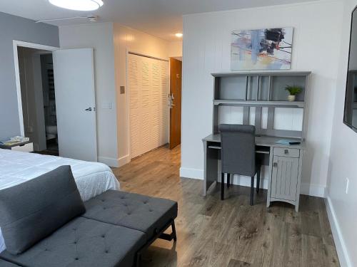 een slaapkamer met een bed en een bureau met een stoel bij Modernized Studio Apartment in Gadsden, AL in Gadsden