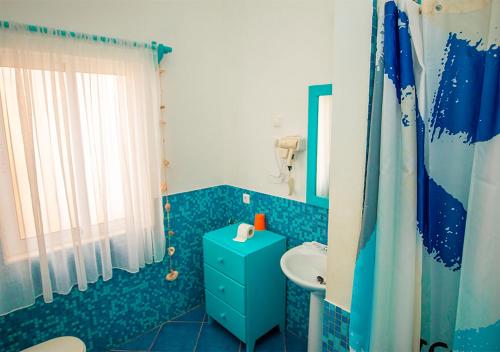 Baño azul con aseo y lavamanos en Villa Atum. Stella Maris Exclusive en Vila do Maio