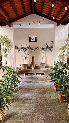a patio with potted plants and a table with a vase at Hotel Rio in Guarujá