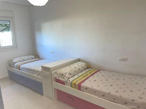 2 aparte bedden in een slaapkamer met een raam bij Moderna y alegre vivienda junto al mar . in Roquetas de Mar