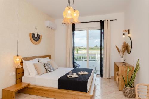 a bedroom with a bed and a balcony at Althea Apartments in Kolymbia