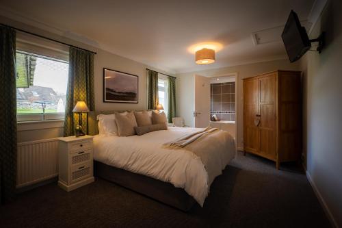 um quarto com uma cama grande e uma janela em Balmridge House, Loch Ness, Bed & Breakfast em Drumnadrochit