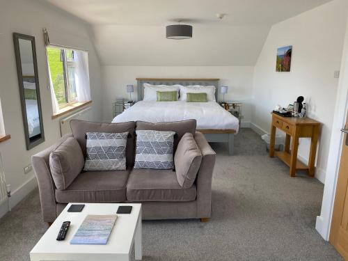 een woonkamer met een bank en een bed bij Kerryanna Country House Bed and Breakfast in Mevagissey