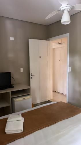a bedroom with a bed with a door and a closet at Hotel Rio in Guarujá