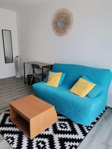 un canapé bleu dans un salon avec une table dans l'établissement Studio les minimes avec parking privatif couvert, à La Rochelle
