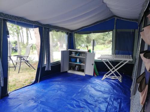 a tent with a desk in the middle at Camping La Chapelle 