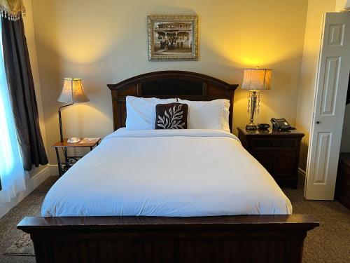a bedroom with a large white bed with two lamps at Historic Branson Hotel - Heritage Room with Queen Bed - Downtown - FREE TICKETS INCLUDED in Branson