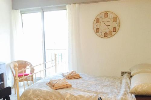 a bedroom with a clock on the wall and a bed at St Tropez Studio in Saint-Tropez