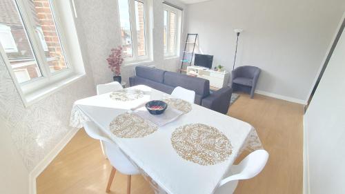 une table blanche et des chaises dans un salon dans l'établissement Cantimpré6 trois pièces centre très lumineux, à Cambrai