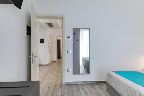 a bedroom with a bed and a mirror at Elegance Suite Apartments - Siroli Collection in Cervia