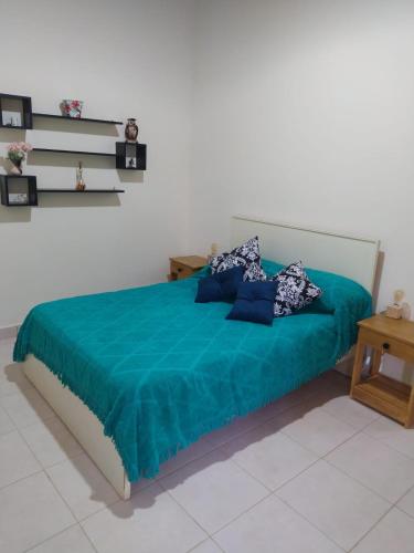 a bedroom with a bed with a blue blanket at Colibri Apart Eldorado in Eldorado