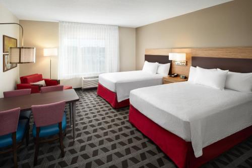 um quarto de hotel com duas camas e uma mesa e cadeiras em TownePlace Suites by Marriott Leesburg em Leesburg