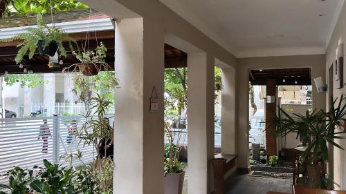 a porch with potted plants and a building at Hotel Rio in Guarujá